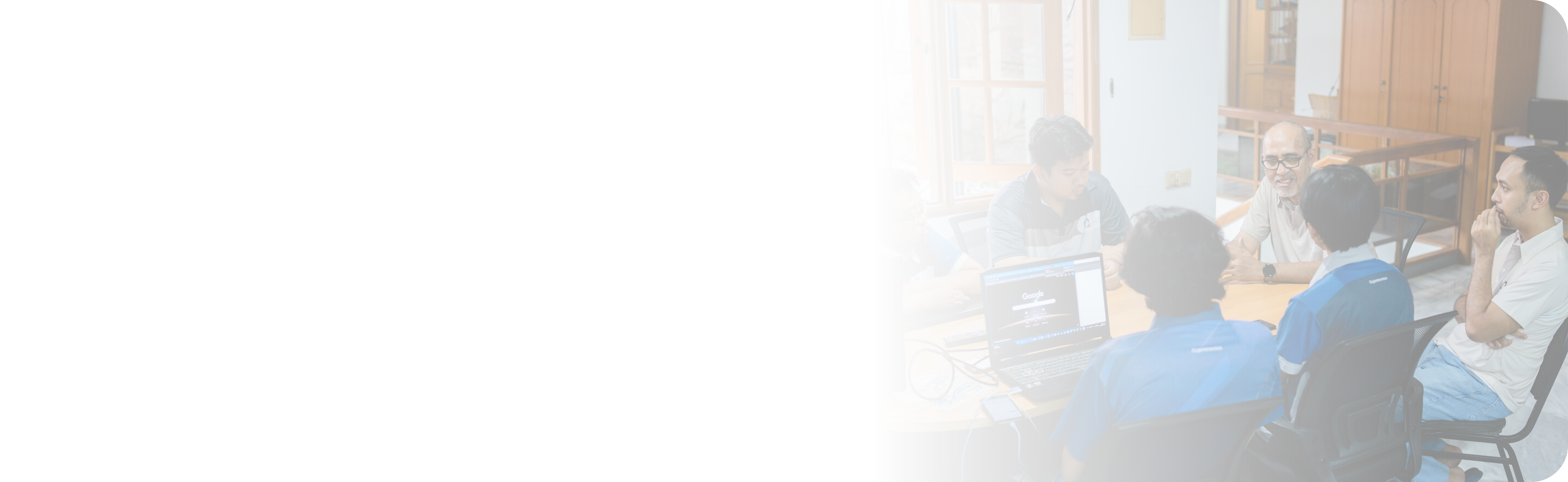 Qimtronics engineers reviewing a project together around a laptop.